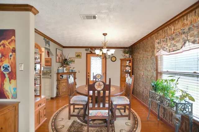 a living room with lots of furniture wooden floor and a large window