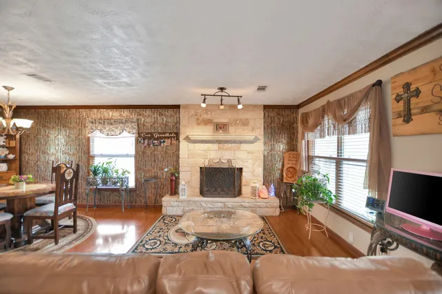 a living room with furniture large window and wooden floor