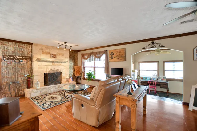 a dining room with furniture a chandelier and wooden floor