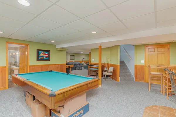 a living room with furniture pool table and blue walls