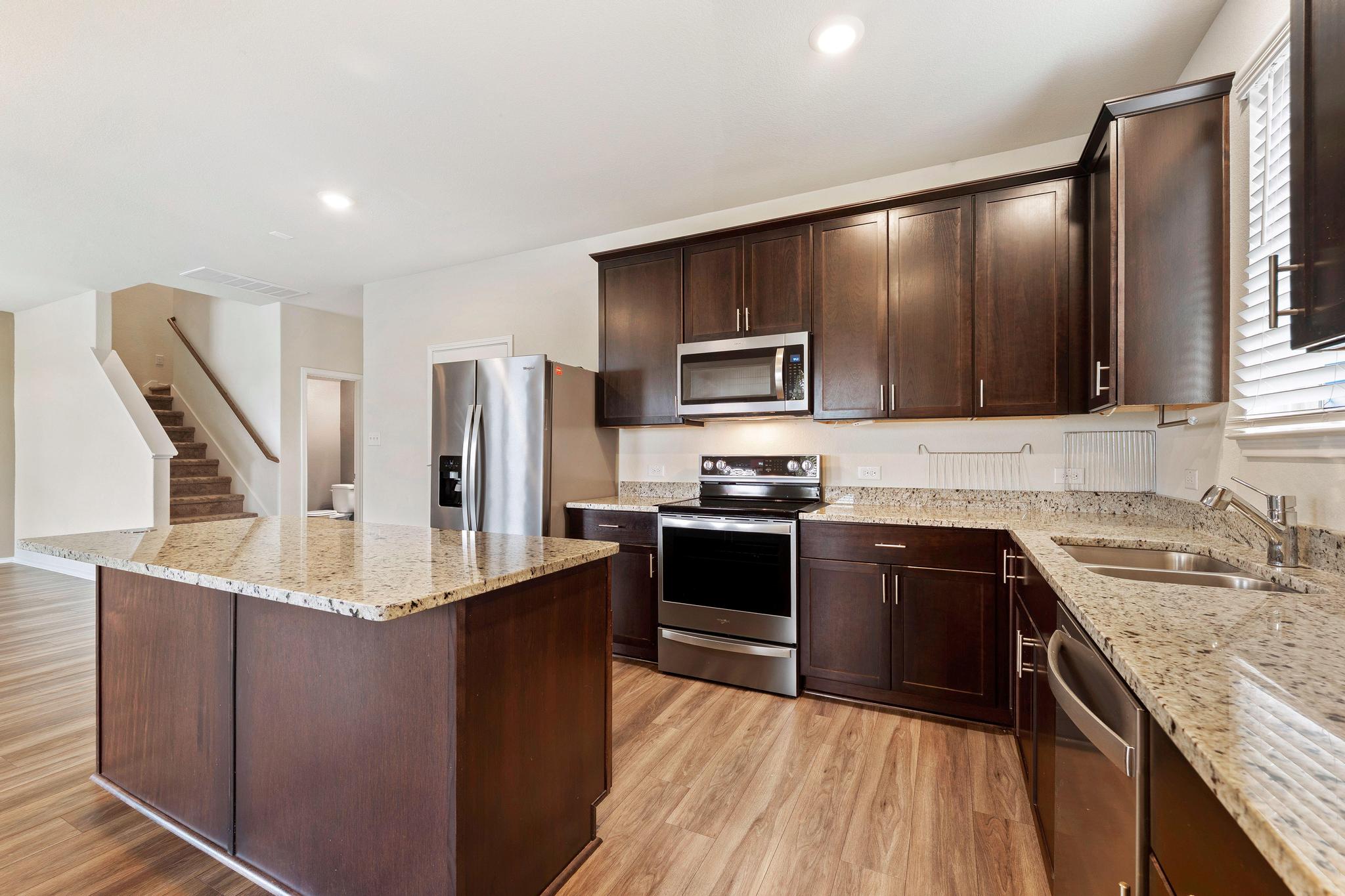 217 Innisfree Road Jarrell, TX 76537 - Photo 15 of 39 A well-appointed kitchen features rich cabinetry, lustrous granite counters, and integrated stainless steel appliances.