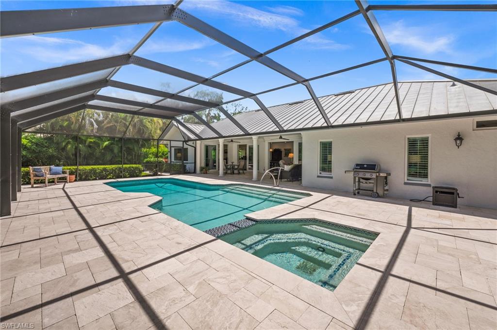 2003 Duke Drive Naples, FL 34110 - Photo 36 of 49 a view of a backyard with table and chairs under an umbrella