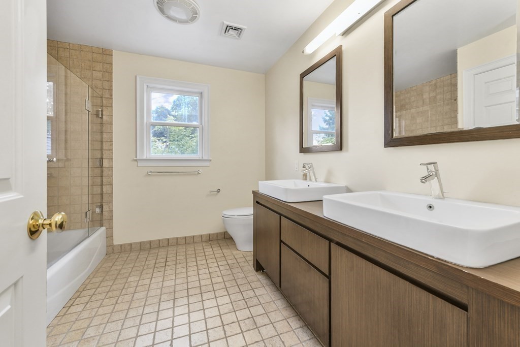 39 Brooks Road Lincoln, MA 01773 - Photo 20 of 40 a bathroom with a double vanity sink a mirror and a bathtub