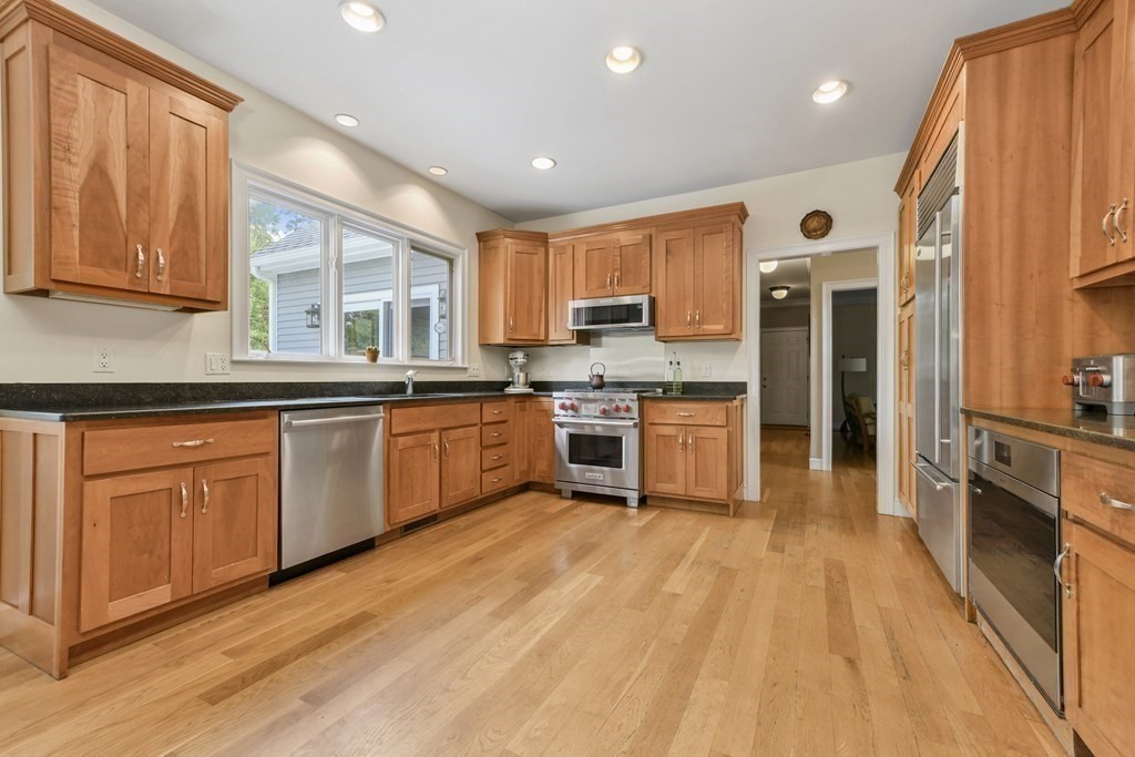 39 Brooks Road Lincoln, MA 01773 - Photo 9 of 40 a kitchen with stainless steel appliances granite countertop wooden cabinets a sink a stove a refrigerator and island with wooden floor