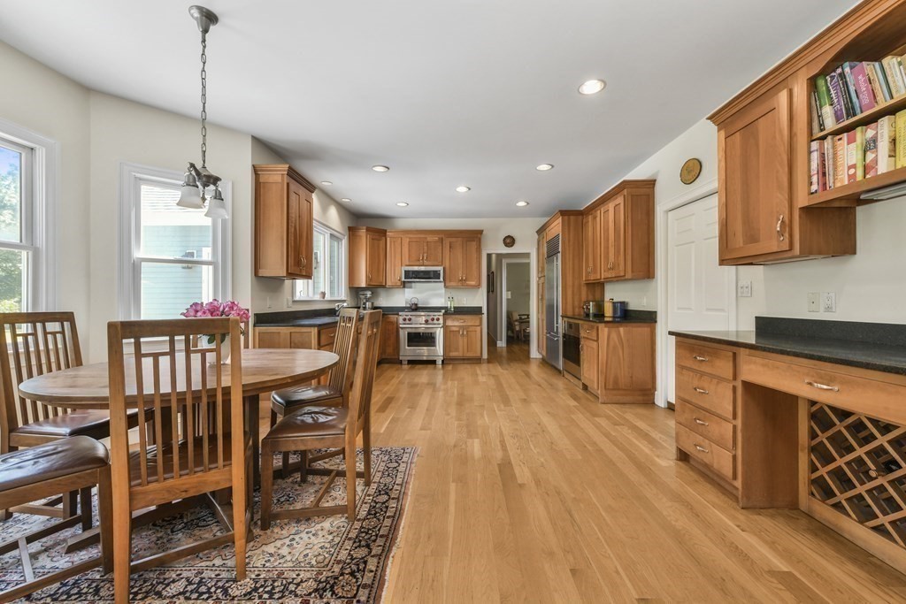 39 Brooks Road Lincoln, MA 01773 - Photo 10 of 40 a kitchen with stainless steel appliances kitchen island granite countertop a table chairs and a wooden floor