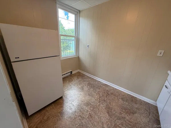 a view of a kitchen with refrigerator and window