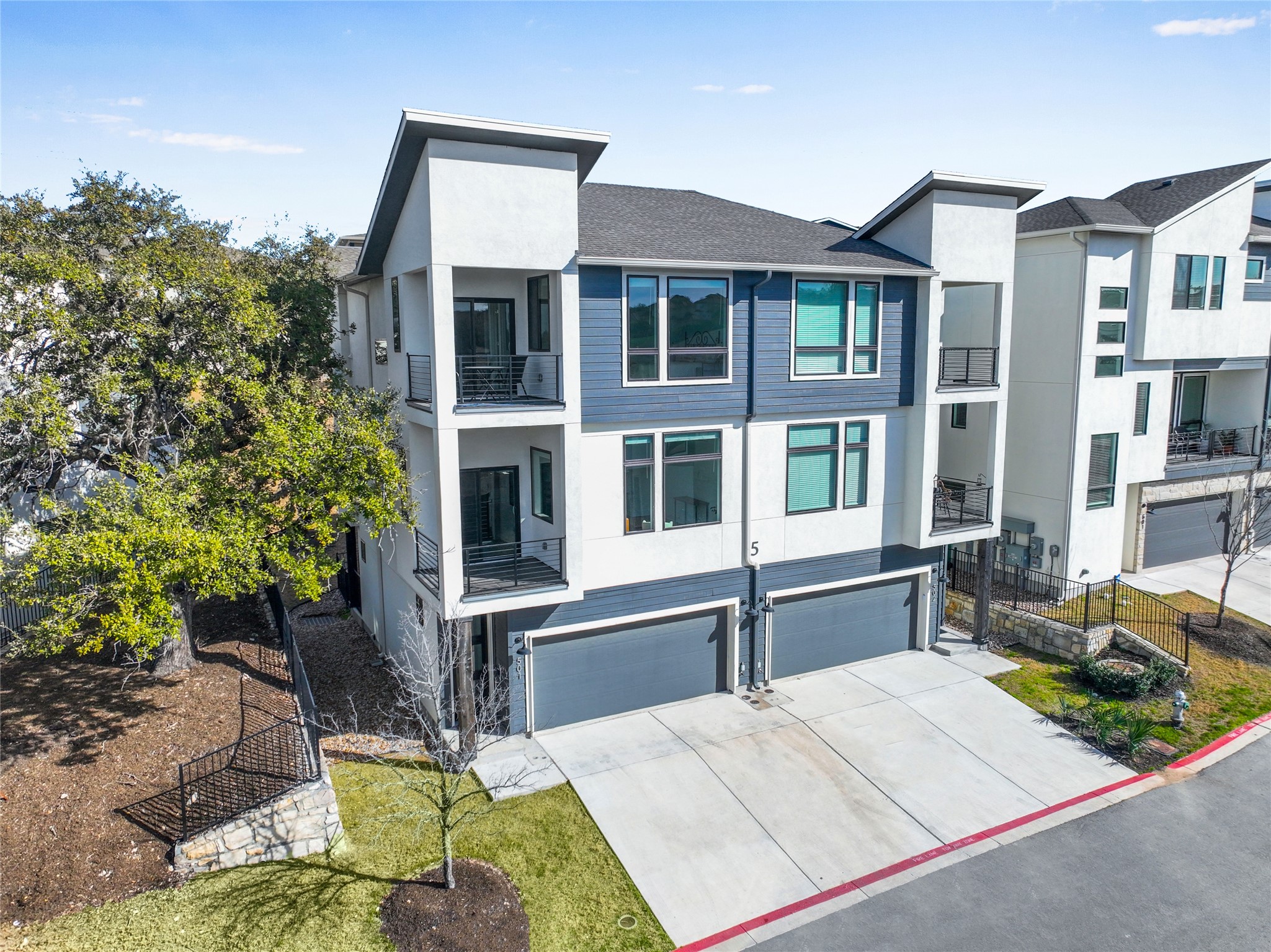 View of front of home featuring concrete driveway, stucco siding, fence, an attached garage, and a shingled roof
