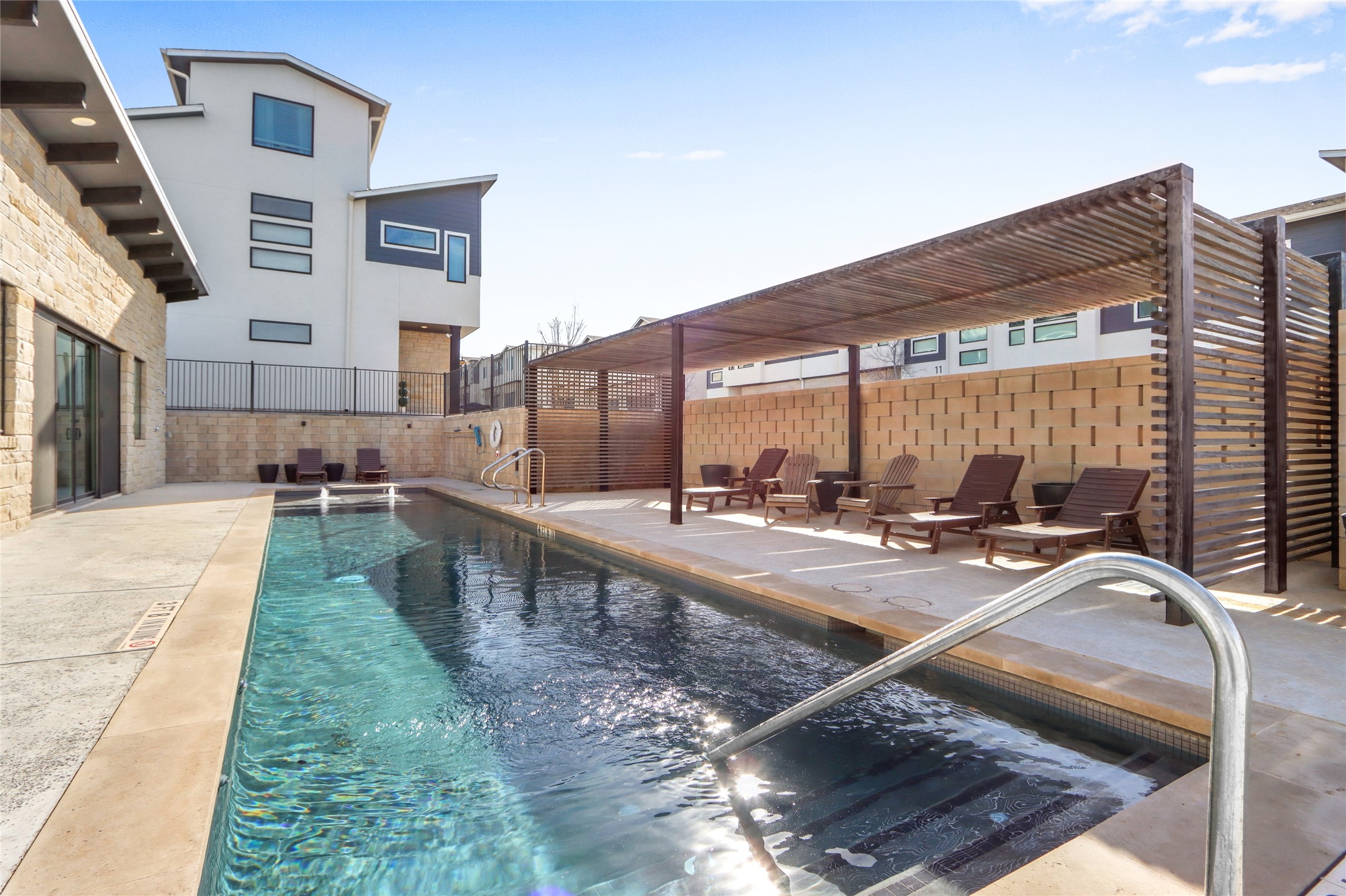 2050 Lohmans Spur Road, Unit 501 Lakeway, TX 78738 - Photo 29 of 40 a view of a swimming pool with a lounge chairs
