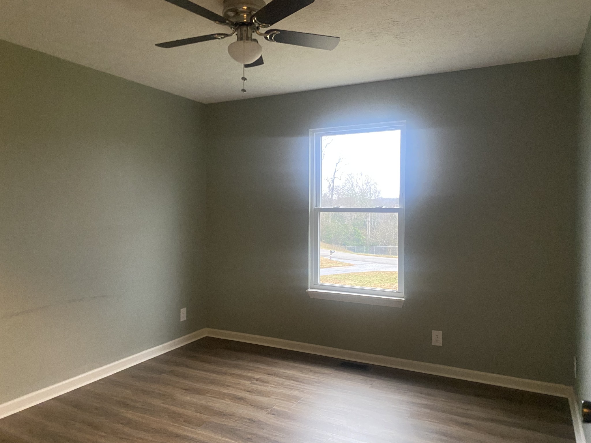 575 Simmons Cemetery Road Quebeck, TN 38579 - Photo 10 of 16 an empty room with wooden floor windows and fan