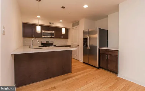 a kitchen with stainless steel appliances granite countertop a refrigerator a sink a stove a microwave and island