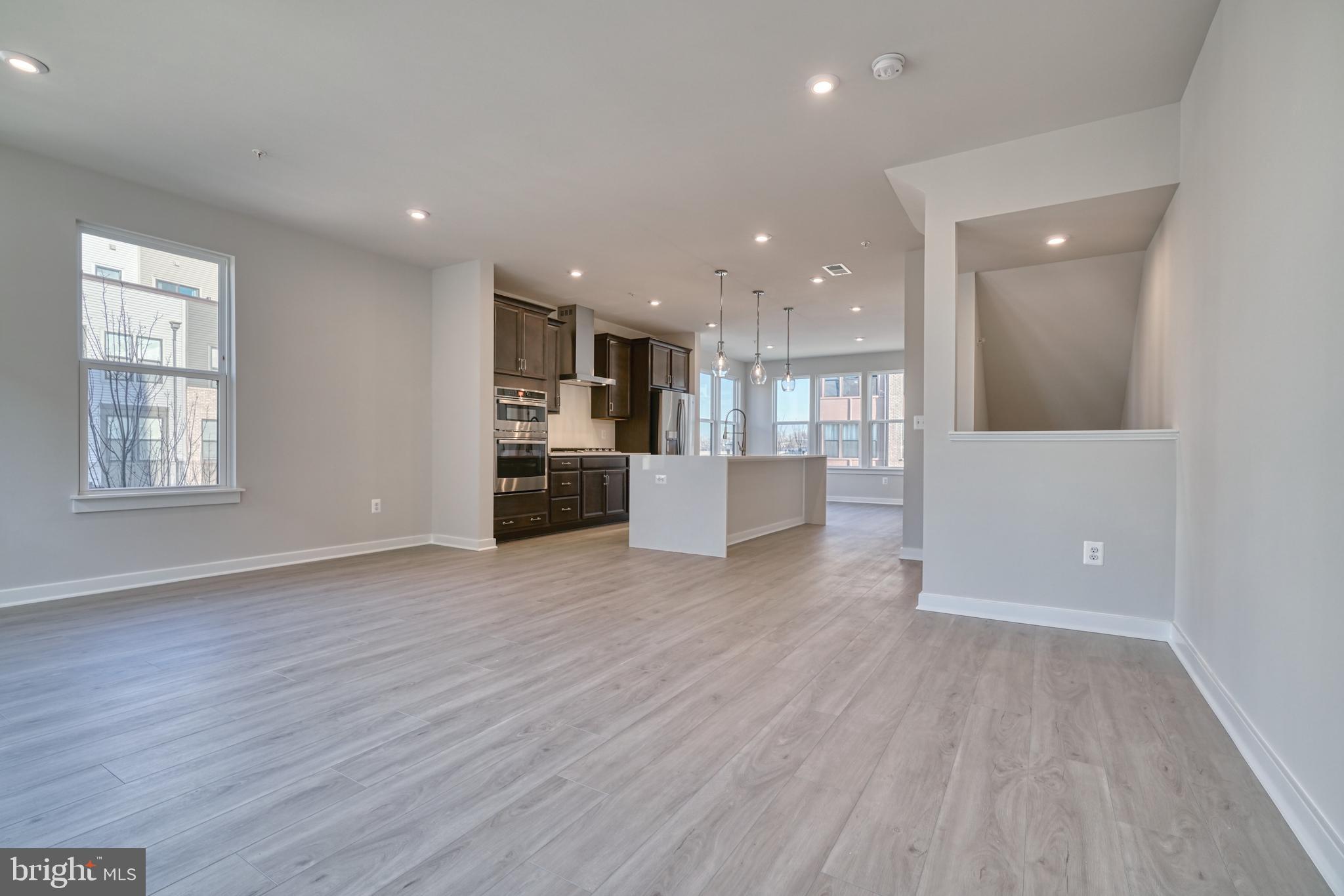 5612 Alpha Ridge Avenue Hyattsville, MD 20782 - Photo 20 of 70 an empty room with wooden floor and kitchen