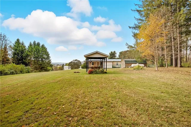 a front view of a house with a yard and trees
