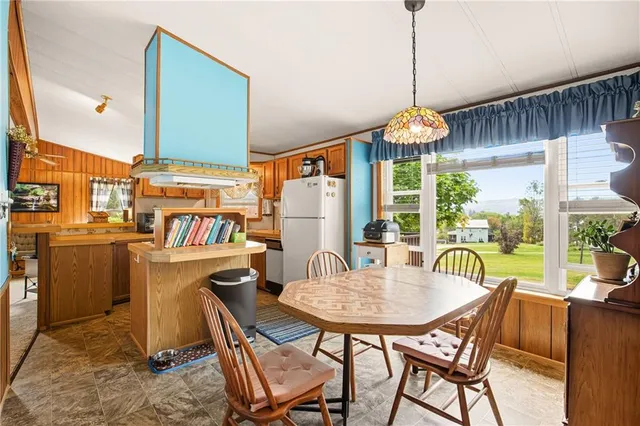 a dining room with furniture a chandelier and wooden floor