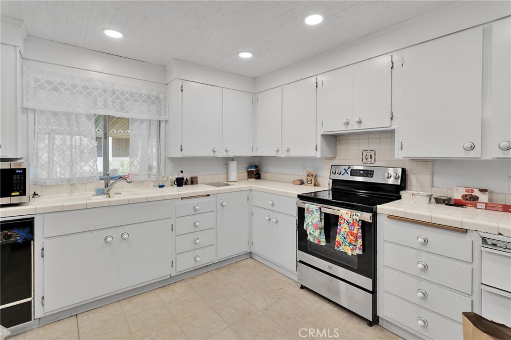 2494 Main Street Barstow, CA 92311 - Photo 16 of 36 a kitchen with cabinets appliances a sink and a window