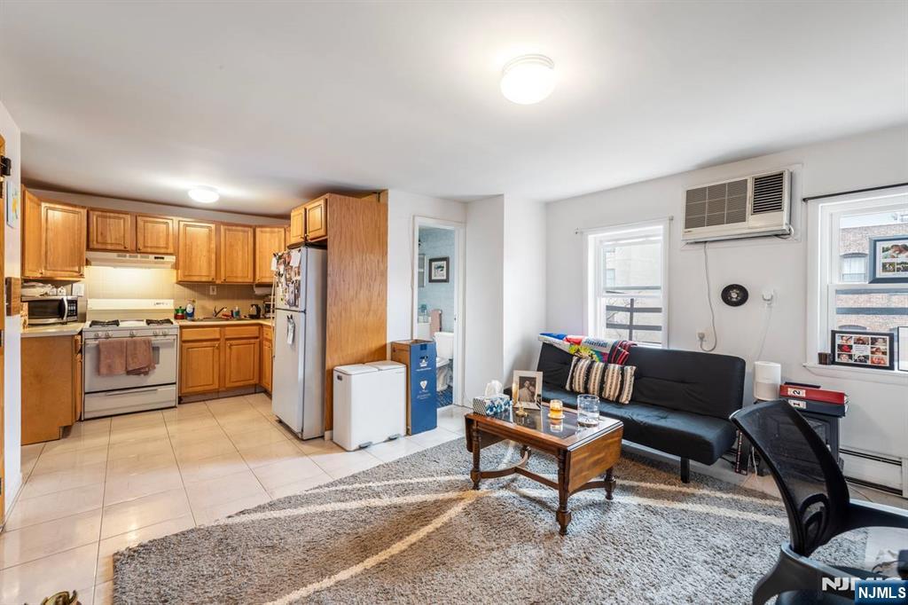 413 Adams Street Hoboken, NJ 07030 - Photo 8 of 40 a living room with furniture a refrigerator and a fireplace