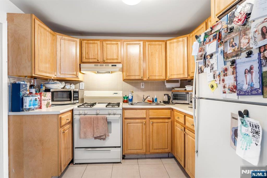 413 Adams Street Hoboken, NJ 07030 - Photo 9 of 40 a kitchen with a white cabinets and window