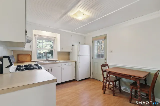a kitchen with a table chairs stove and refrigerator