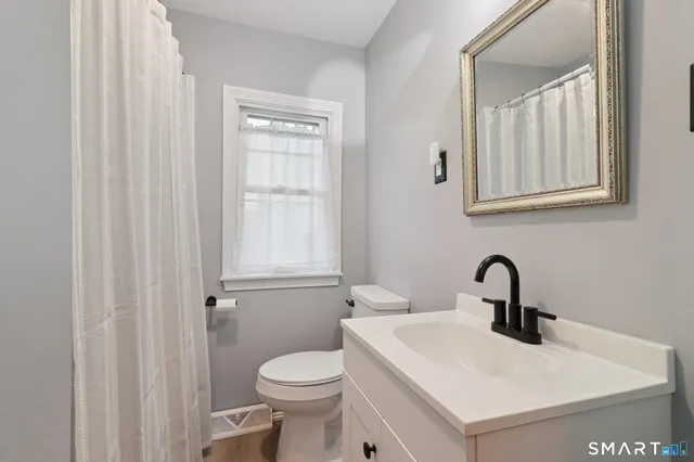 a bathroom with a sink a toilet and mirror