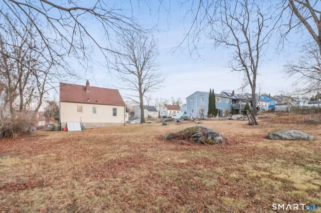 a view of a large white house with a yard covered in the snow