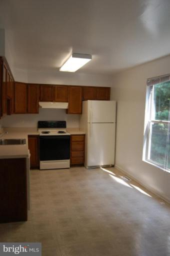 69 Kinsman View Circle Silver Spring, MD 20901 - Photo 4 of 12 a kitchen with stainless steel appliances a stove a refrigerator a sink a stove with wooden floors