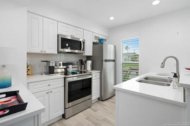 a kitchen with stainless steel appliances granite countertop a stove a sink and a refrigerator