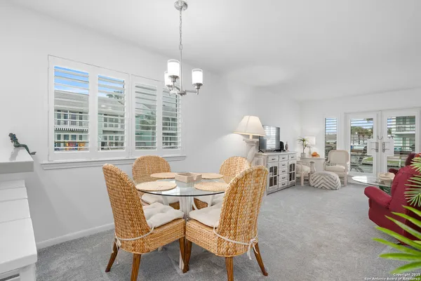 a view of a dining room with furniture a chandelier and wooden floor