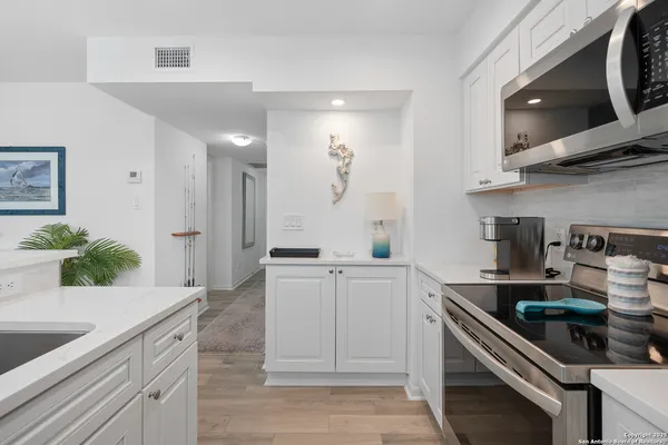 a kitchen with stainless steel appliances granite countertop a sink and cabinets