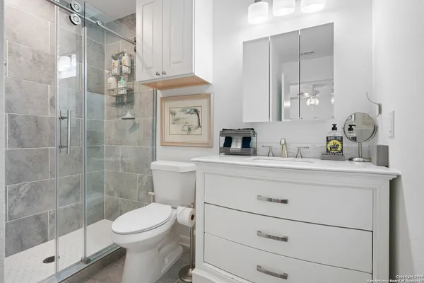 a bathroom with a sink a toilet and shower