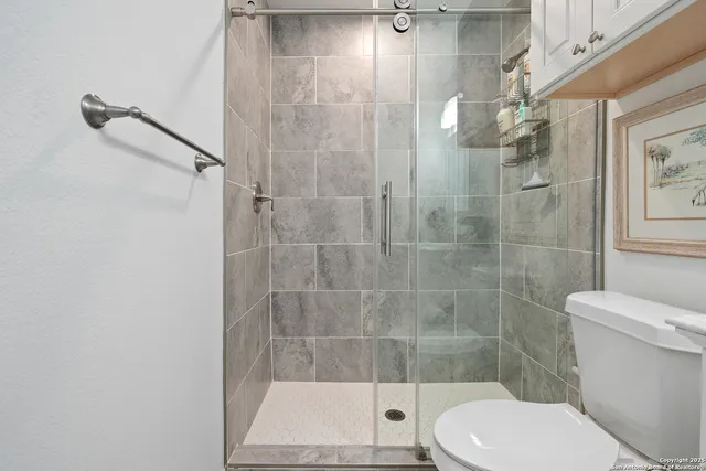 a bathroom with a toilet and a shower