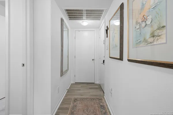 a view of a hallway with wooden floor and entryway