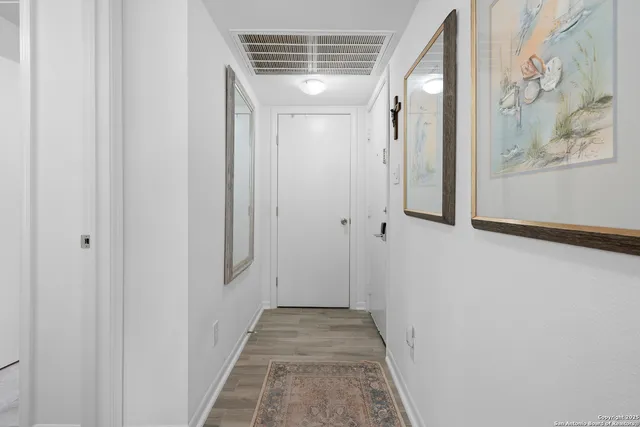 a view of a hallway with wooden floor and entryway