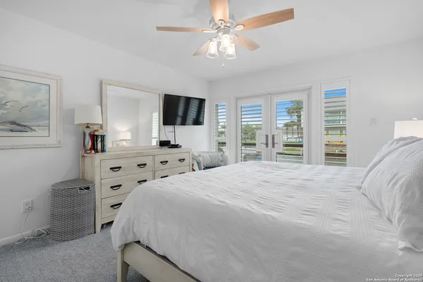 a bedroom with a large bed and a flat tv screen on dresser