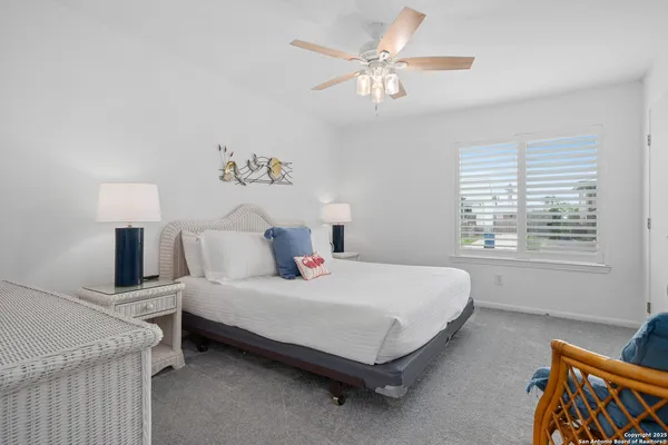 a bedroom with a bed a chandelier and a window