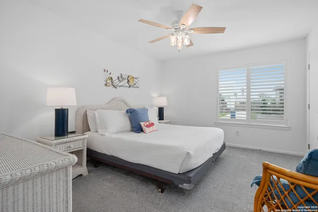 a bedroom with a bed a chandelier and a window