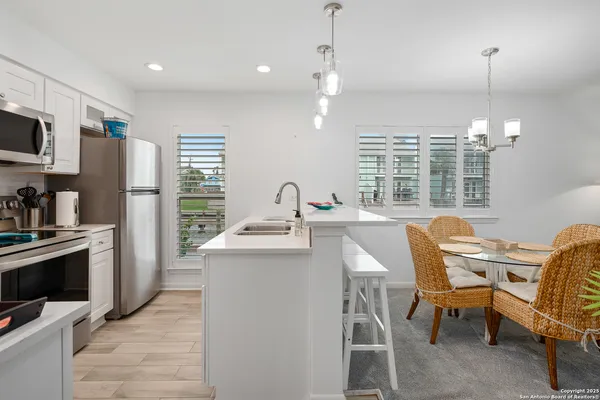 a kitchen with stainless steel appliances kitchen island granite countertop a sink and a refrigerator