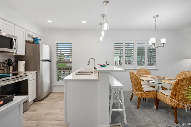 a kitchen with stainless steel appliances kitchen island granite countertop a sink and a refrigerator