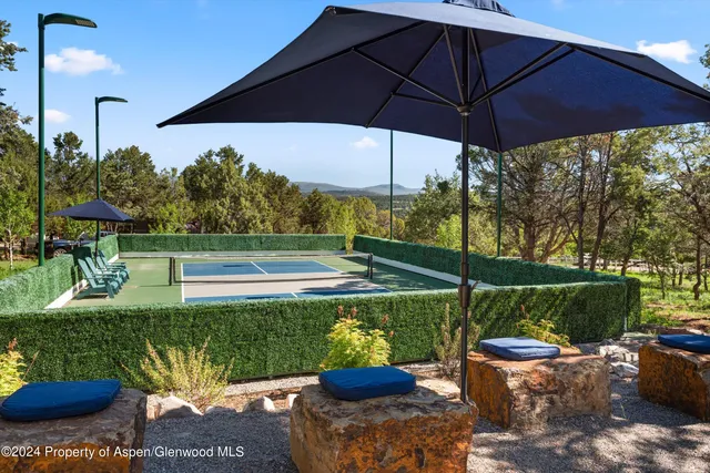 a view of a patio with a table and chairs under an umbrella