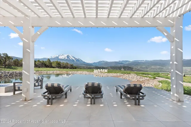 a living room with furniture a fireplace and a large window