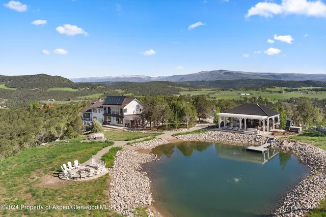 a living room with fireplace furniture and a large window