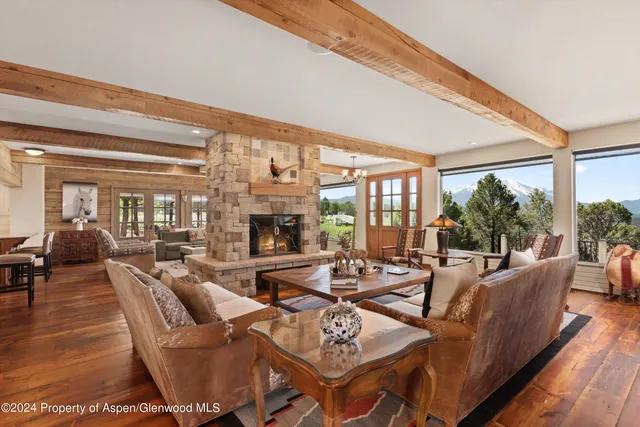 a living room with furniture a flat screen tv and a floor to ceiling window