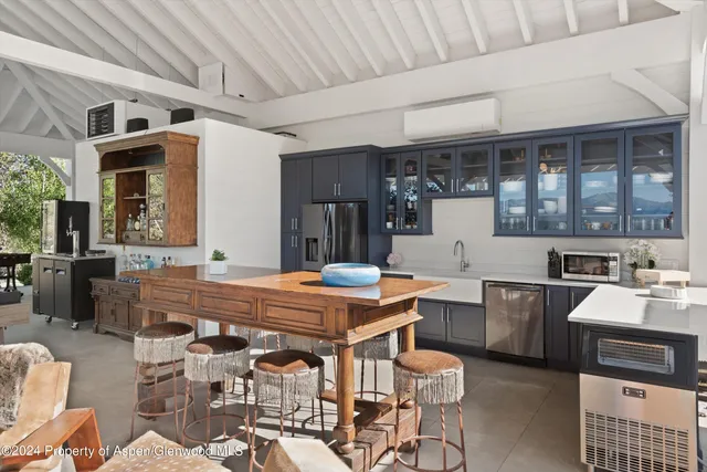a view of a table and chairs under an umbrella in backyard