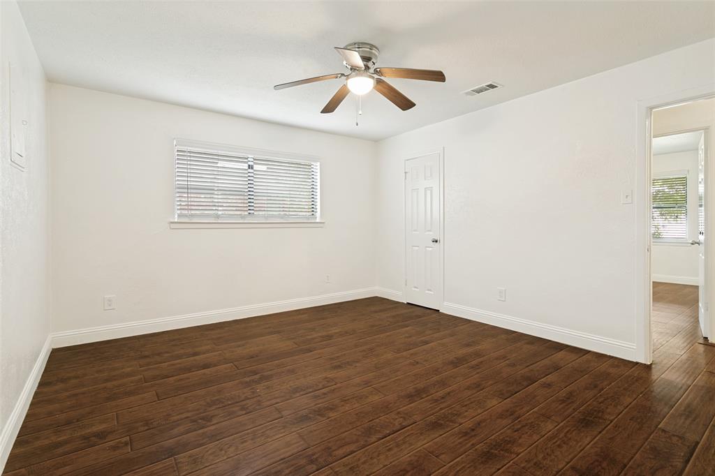 1904 Old Kirk Road Bedford, TX 76022 - Photo 20 of 25 an empty room with wooden floor chandelier fan and windows