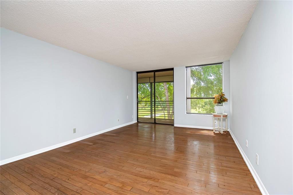 8150 West McNab Road, Unit 312 Tamarac, FL 33321 - Photo 8 of 32 a view of an empty room with wooden floor and a window