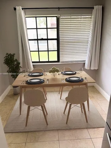 a table and chair in a room next to a window