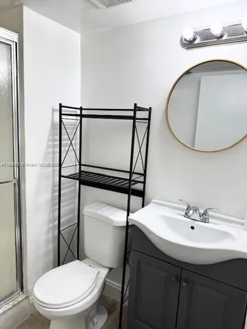 a bathroom with a sink toilet and a mirror