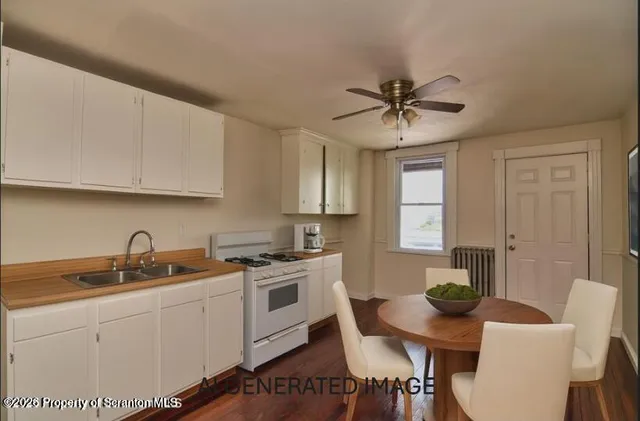 a kitchen with a stove a sink a dining table and chairs