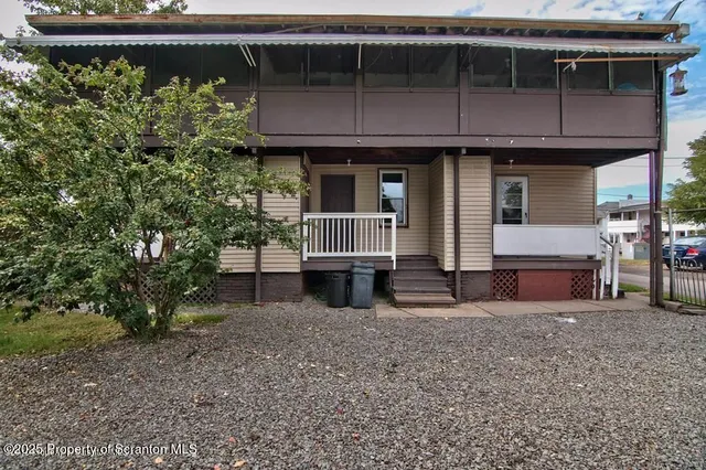a view of house with roof deck and chair