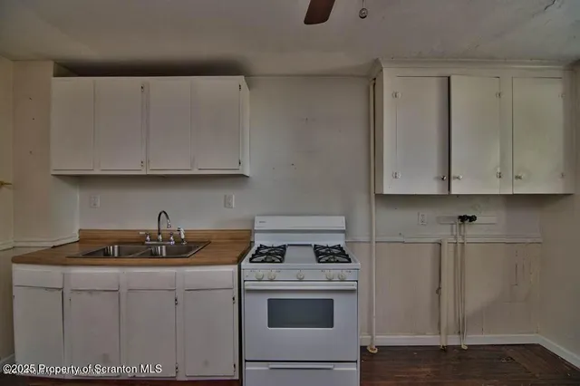 a kitchen with white cabinets and white appliances