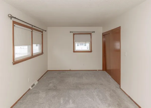 an empty room with windows and closet