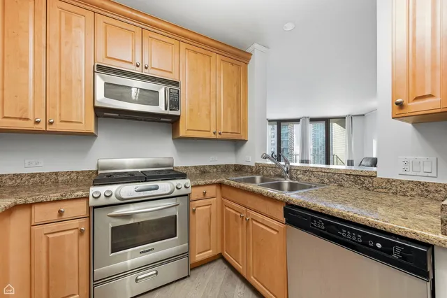 a kitchen with granite countertop cabinets stainless steel appliances and a sink